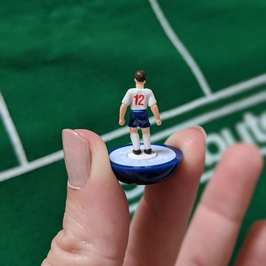 Subbuteo England Edition Main Game player figurine held in hand, showcasing intricate details and iconic design.