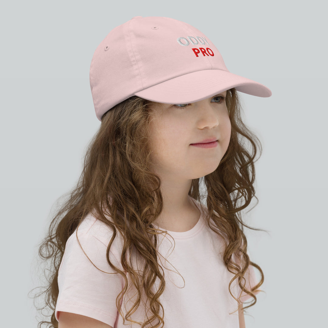 Girl wearing Oddy Pro Youth baseball cap in pink, showcasing stylish design and comfortable fit.